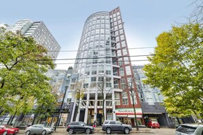 Ein mehrstöckiges Gebäude mit modernem architektonischen Design, gekennzeichnet durch eine markante, gebogene Fassade und eine Kombination aus Glas- und Metallelementen.