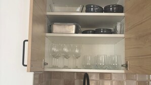 Ett kök med en diskho, ett blandare, en tvåldispenser och ett diskställ.