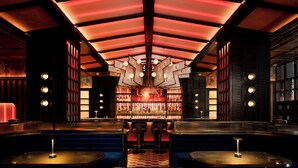 A bar area with a central bar, seating, and a patterned floor.