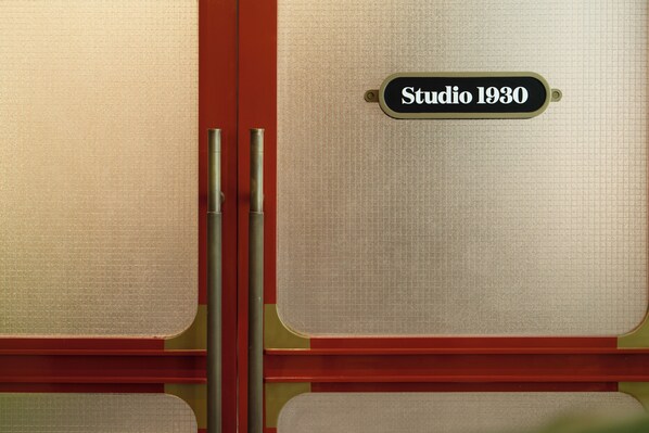 Une porte avec une plaque indiquant « Studio 1930 » et un panneau en verre dépoli.