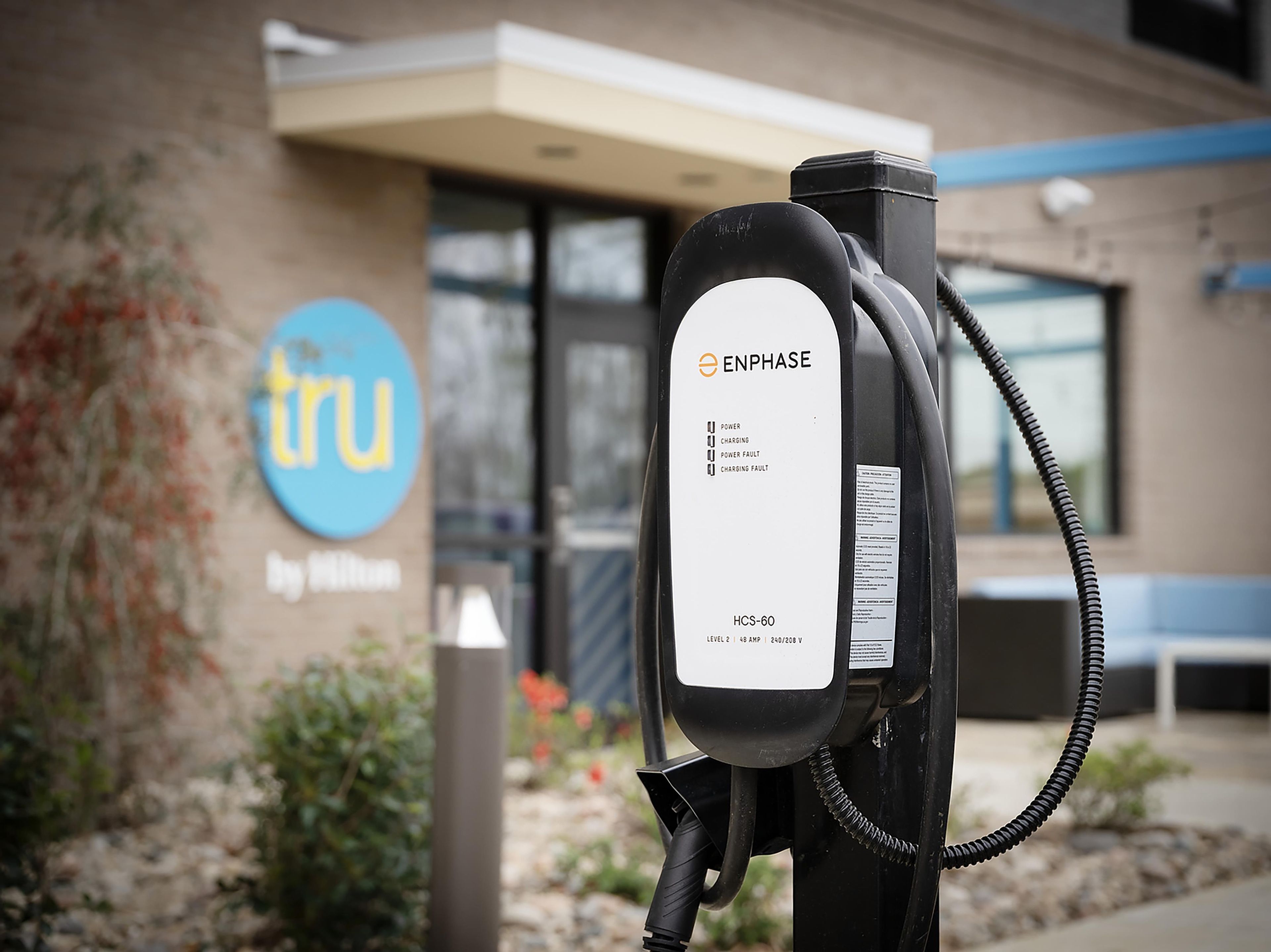 An electric vehicle charging station with a label indicating 'ENPHASE' and 'HCS-60' model.