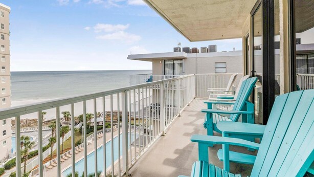 A balcony with turquoise chairs overlooking a pool and the ocean. - Seaside Beach & Racquet 5914 (Orange Beach)