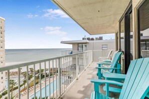 A balcony with turquoise chairs overlooking a pool and the ocean. - Seaside Beach & Racquet 5914 (Orange Beach)