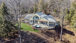 A large house with a deck, a covered porch, and a large window. - Retreat w/ Southern Views | Hot Tub | Club Access (Hartford)
