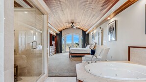 A modern bathroom with a large bathtub, a glass shower enclosure, and a view to a bedroom. - Retreat w/ Southern Views | Hot Tub | Club Access (Hartford)