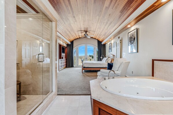A modern bathroom with a large bathtub, a glass shower enclosure, and a view to a bedroom. - Retreat w/ Southern Views | Hot Tub | Club Access (Hartford)