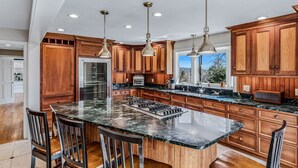 A kitchen with wooden cabinets, a marble countertop, a built-in stove, and pendant lighting. - Retreat w/ Southern Views | Hot Tub | Club Access (Hartford)