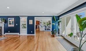 A spacious living area with hardwood flooring, a fireplace, and a view through a sliding glass door. - Retreat w/ Southern Views | Hot Tub | Club Access (Hartford)
