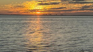 A sunset over a calm body of water with a distant city skyline. - Studio, mini fridge/coffee DT Safety Harbor (Safety Harbor)