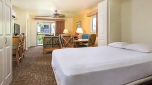 A hotel room with a bed, a desk with two chairs, a window, and a ceiling fan. - Stunning Hawaiian Vacation: 2 Bedroom at WorldMark Kona (Kailua-Kona)