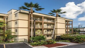 A multi-story hotel with balconies, palm trees, and a landscaped garden. - Stunning Hawaiian Vacation: 2 Bedroom at WorldMark Kona (Kailua-Kona)