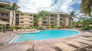 A hotel with a swimming pool, lounge chairs, and palm trees. - Stunning Hawaiian Vacation: 2 Bedroom at WorldMark Kona (Kailua-Kona)