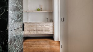A modern kitchen with a marble backsplash, wooden cabinets, and a built-in shelf. - Archimede by Wynwood House (Milan)
