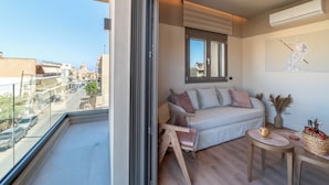 A balcony with a sofa, a small table, and a decorative vase. - Minotaur's Rest (Heraklion)