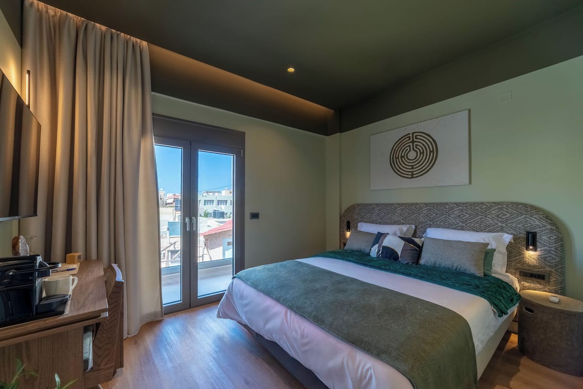 Habitación de hotel moderna con una cama grande, un escritorio y vistas a través del ventanal.