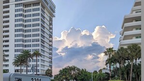 Placa para '2301 Ventura Vacation Rentals', com vista para um edifício de vários andares e palmeiras ao fundo.