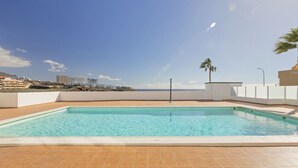 A rooftop swimming pool with a clear view of the beach and cityscape in the background. - Beachfront 1BR with Balcony, Pool & Parking Ancla (Callao Salvaje)