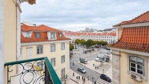 Straßenansicht mit Gebäuden mit roten Ziegeldächern und einer Fußgängerampel.