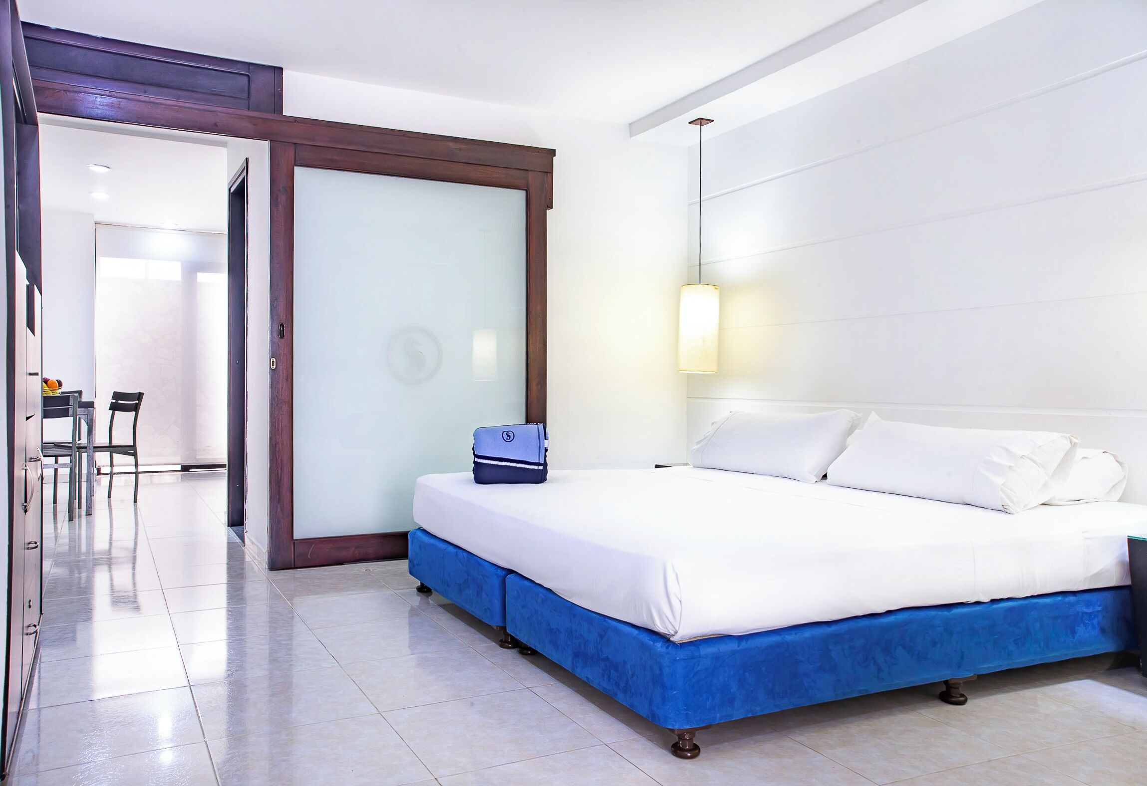 A hotel room with a bed, a desk, and a chair.