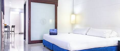 A hotel room with a bed, a desk, and a chair.