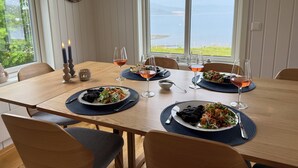 A dining table set with plates of food, glasses of wine, and candles.