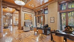 Eine geräumige Lobby mit Holzboden, einer großen Kandelaberleuchte und einer Rezeption.