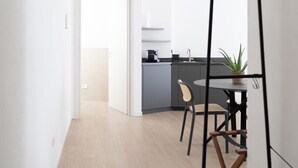 Eine moderne Küche mit grauen Schränken, einer schwarzen Arbeitsplatte und einem Blumentopf.