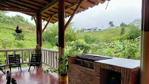 A covered outdoor area with a grill and seating.