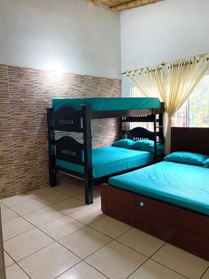 A room with a bunk bed, a single bed, tiled flooring, and a window with curtains. - Country house with private pool for 26 people, 45 minutes from Pereira. (Pereira)