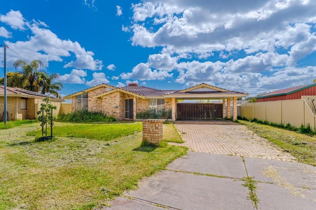 A two-story house with a brick exterior, a front porch, and a paved driveway.