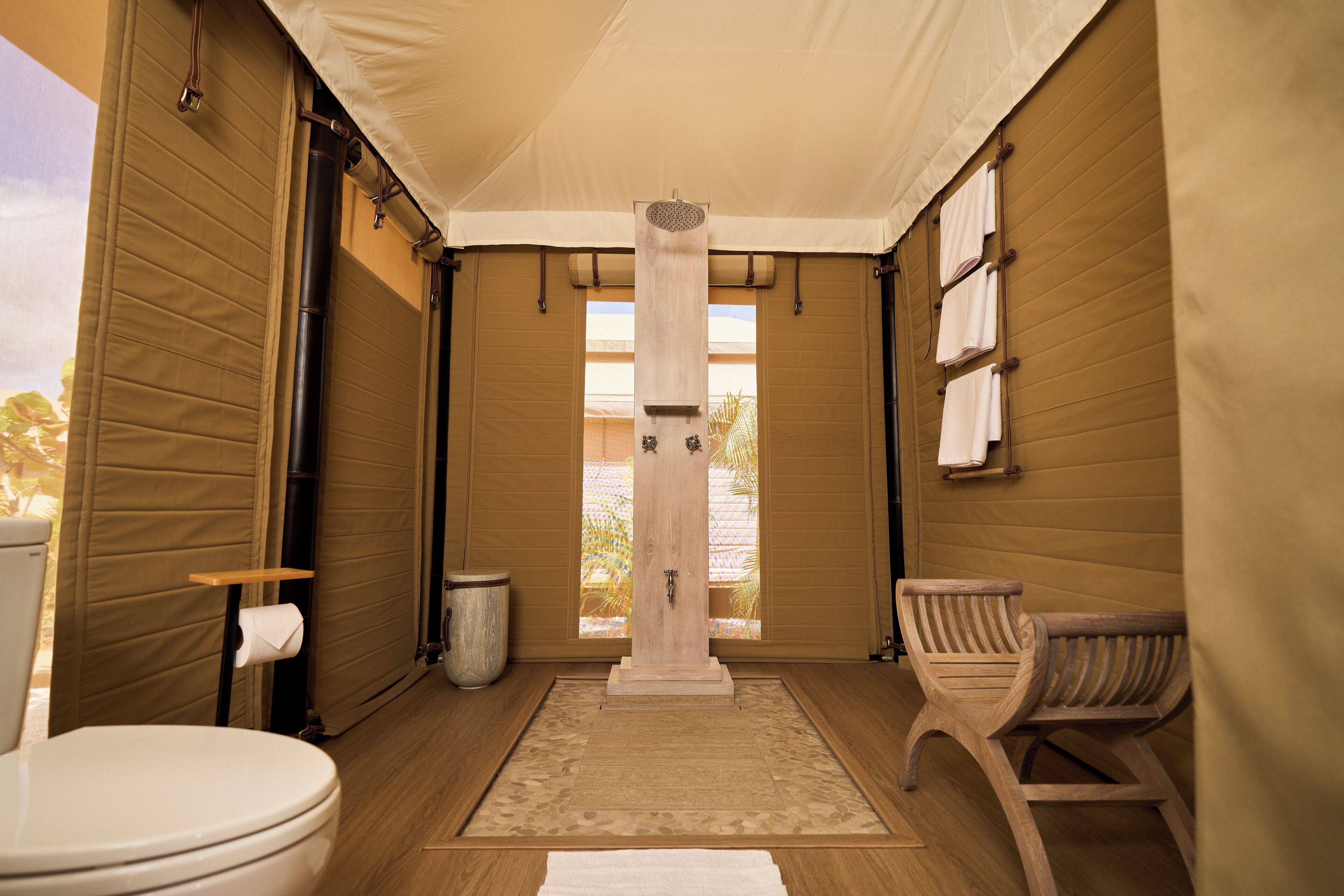 Un baño con suelo de madera, inodoro, lavabo y zona de ducha.