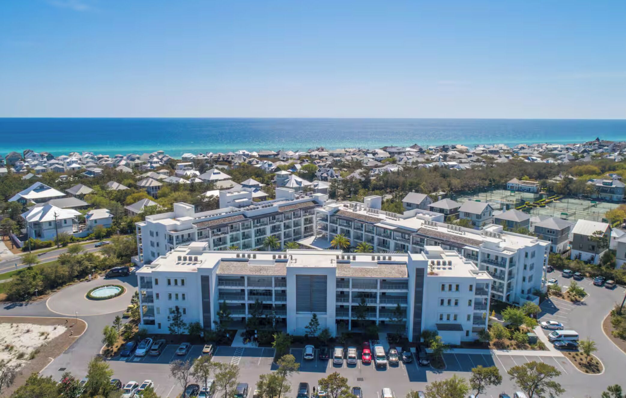 A modern hotel with a central courtyard, surrounded by a coastal residential area.