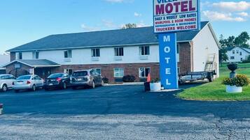 Motel Villa Inn con un cartel que indica tarifas bajas diarias y semanales, hidromasaje y teléfono en la habitación, refrigerador y microondas, y una cálida bienvenida para camioneros.