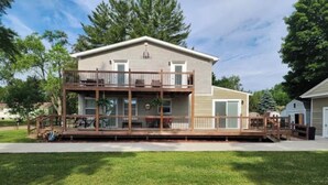 A two-story house with a balcony, a deck, and a front yard.