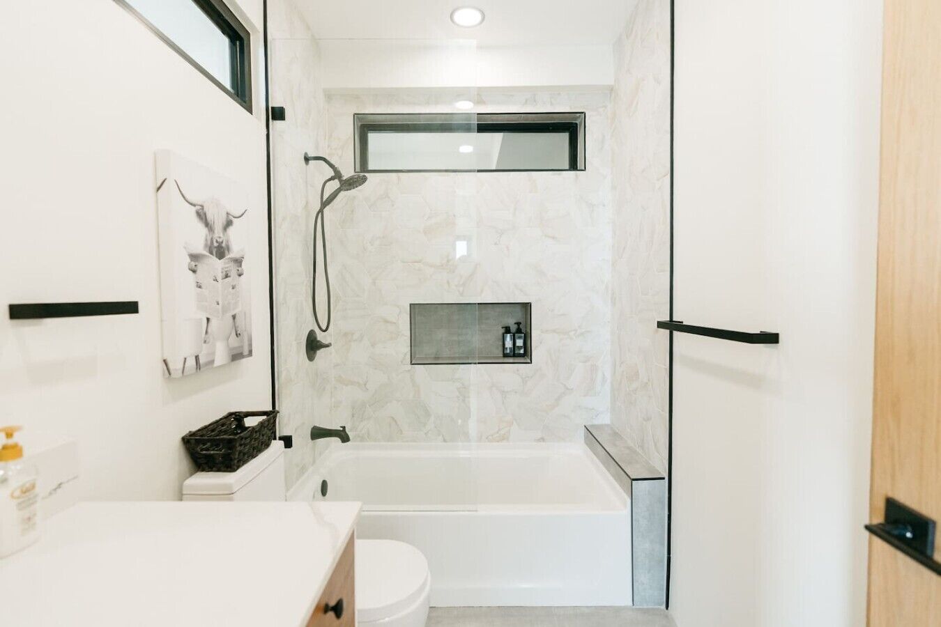 A modern bathroom with a bathtub, toilet, and shower.