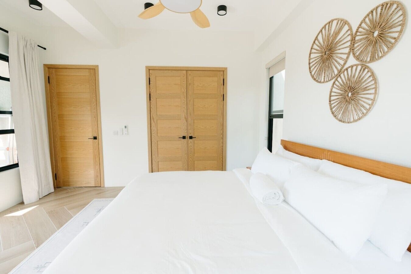 Un dormitorio con una cama grande, puertas de madera y un ventilador de techo.