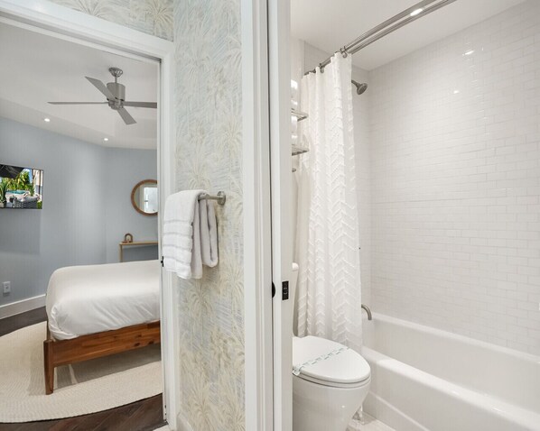 A bathroom with a bathtub, toilet, and shower curtain. - Private Waterfront Luxury Villa | Resort-Style Living & Privacy (Fort Lauderdale)