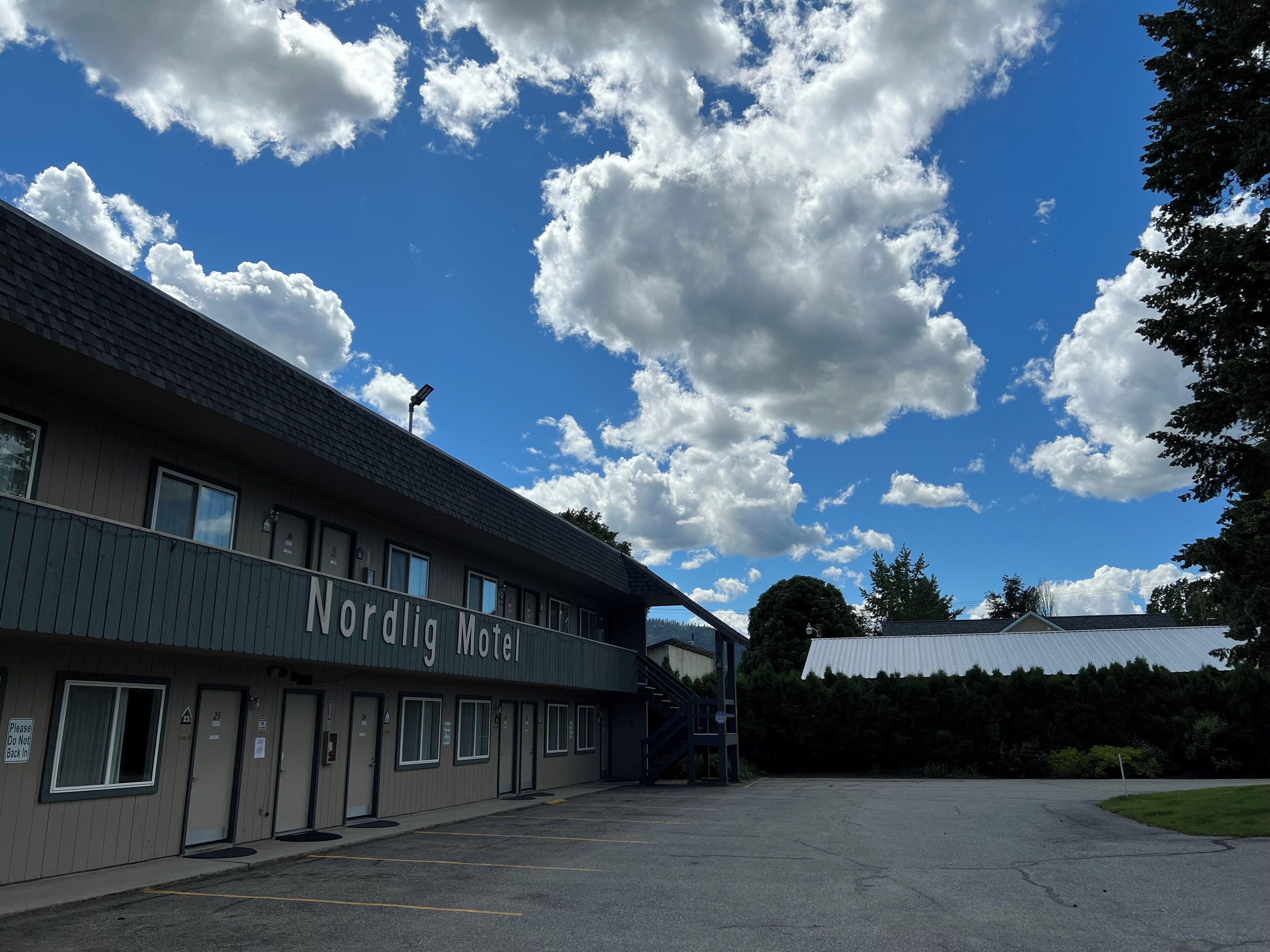 A Nordia Motel with a parking lot and a clear sky with clouds.