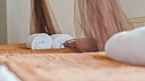 Cama com colcha marrom e toalha branca.