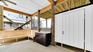 Una cucina moderna con travi in legno, una panca, un lavello e un armadietto bianco.
