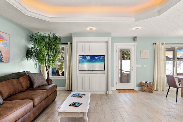 Sunny coastal living with leather sofa, built-in TV & patio access