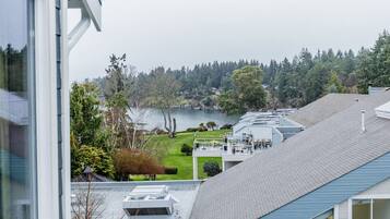 A residential building with a view of a lake, a covered outdoor area, and a sloped roof.