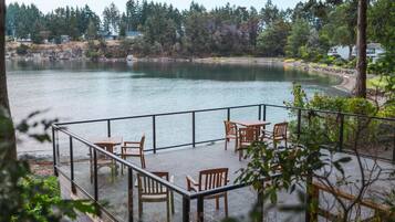 A lakeside patio with outdoor seating and a view of the lake.