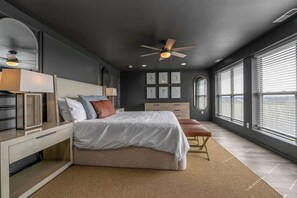 Une chambre à coucher moderne avec un lit, une table de chevet et un banc.