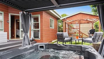 A hot tub area with outdoor seating and a wooden deck.
