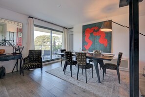 Ein moderner Essbereich mit großem Tisch, gemusterten Stühlen und einem großen abstrakten Gemälde an der Wand.
