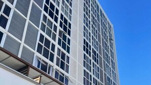 Un edificio moderno con una fachada de ventanas en cuadrícula y un techo plano.