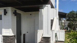 A modern house with a covered porch, stone pillars, and a well-maintained lawn. - SUNNY POIPU, 2 beds rooms-2 bathrooms, air conditioning  (Koloa)