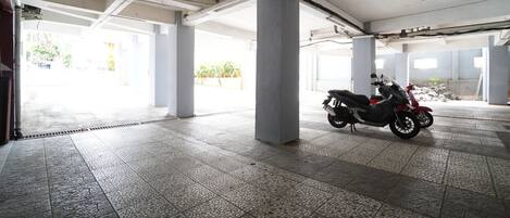 A parking garage with tiled floors and concrete pillars.