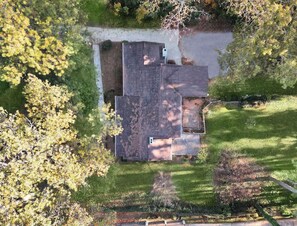 Vista aèria d'una propietat residencial amb una casa gran, una entrada de cotxes i vegetació als voltants.